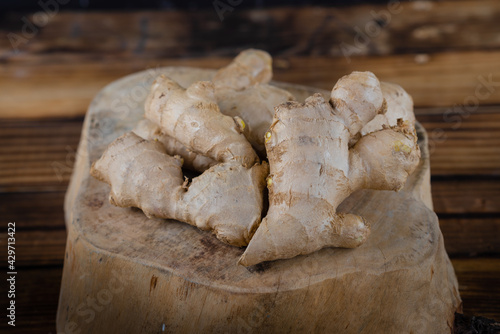 fresh ginger root on rustic wooden board blackground