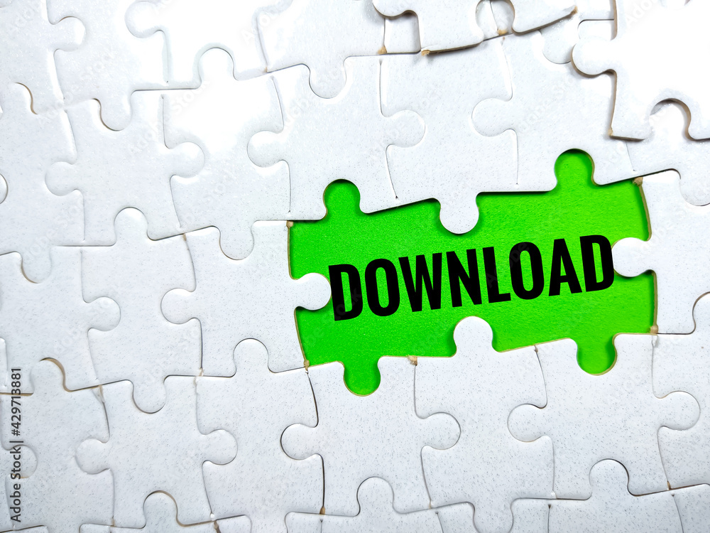 Selective focus.Word DOWNLOAD with jigsaw puzzle on green background. Selective focus.Word DOWNLOAD with jigsaw puzzle on green background.