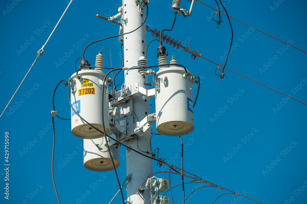 Electric pole and electric transformer on background clear blue sky. Electrical power lines. High voltage metal cable. Good for Electric Company job, news, advertising, billboards. Electric pole and electric transformer on background clear blue sky. Electrical power lines. High voltage metal cable. Good for Electric Company job, news, advertising, billboards.