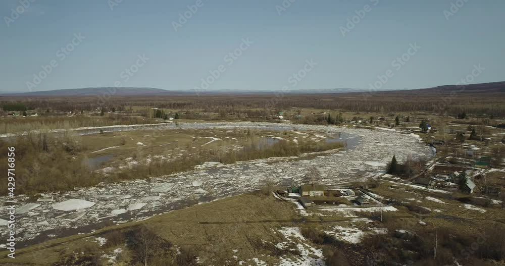 Flooded areas with ice destruction Ice drift through the village in the wild. Floating chunks destruction of ice in a muddy river. Aerial drone view at spring sunny day. Flooded areas with ice destruction Ice drift through the village in the wild. Floating chunks destruction of ice in a muddy river. Aerial drone view at spring sunny day.