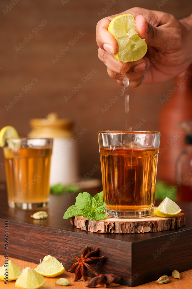 Making Lime tea , black tea Chai traditional beverage with lemon spices Kerala India. Two glass of organic ayurvedic or herbal drink India, green tea good in winter for immunity boosting. Making Lime tea , black tea Chai traditional beverage with lemon spices Kerala India. Two glass of organic ayurvedic or herbal drink India, green tea good in winter for immunity boosting.
