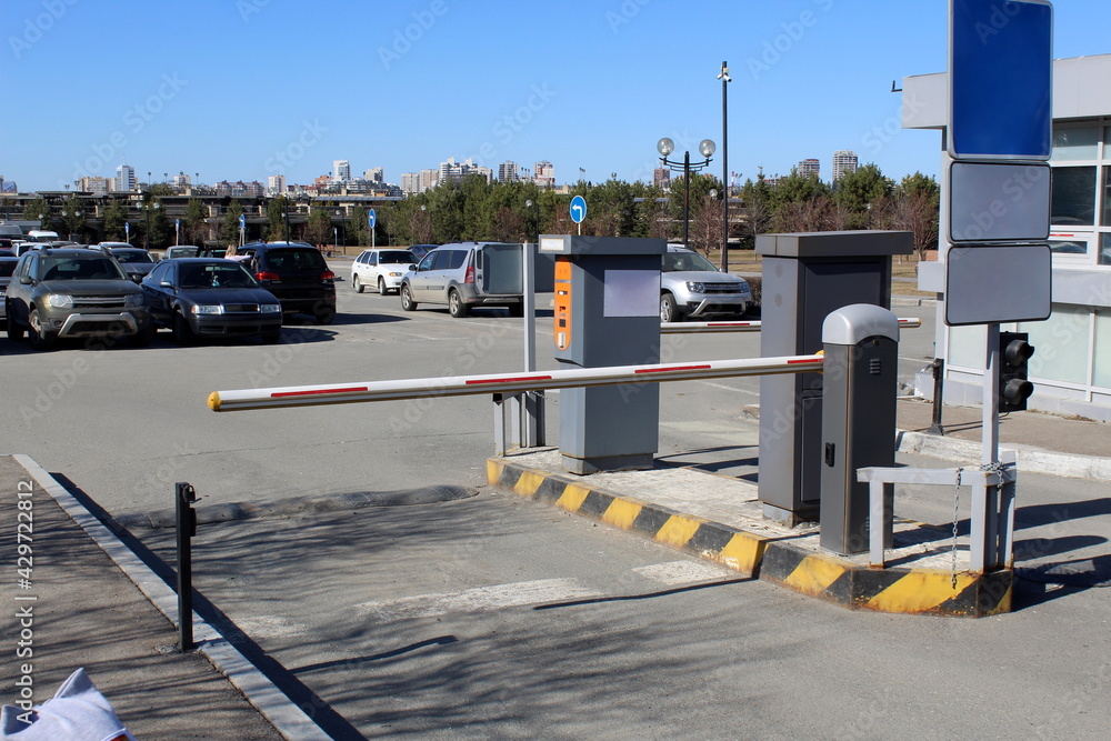 Closed barrier in a paid parking lot, warm sunny day Closed barrier in a paid parking lot, warm sunny day