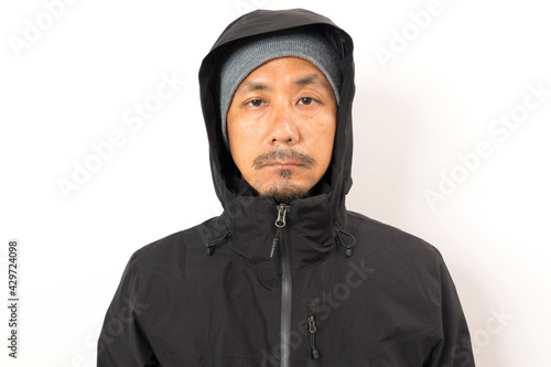 Middle age Asian man wearing black winter jacket with glove and hat.