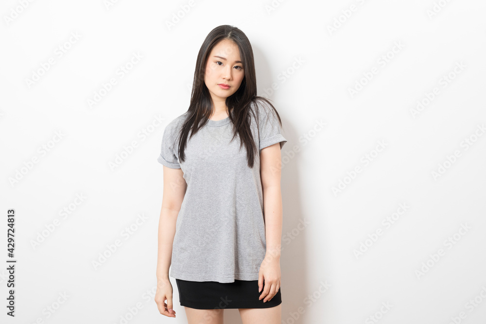 Portrait of beautiful young asian woman wearing grey shirt over white background. Portrait of beautiful young asian woman wearing grey shirt over white background.