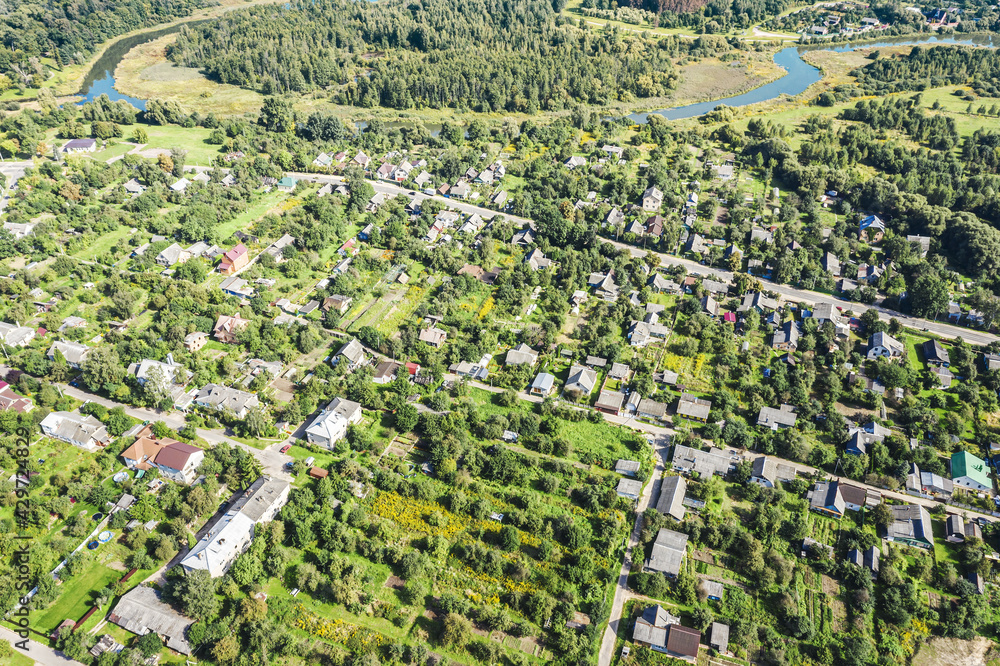 aerial panoramic view of a residential neighborhood with homes and trees near river on a spring sunny day