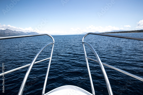 Closeup of metal handrail at the edge of the boat's deck on an ocean water background photo