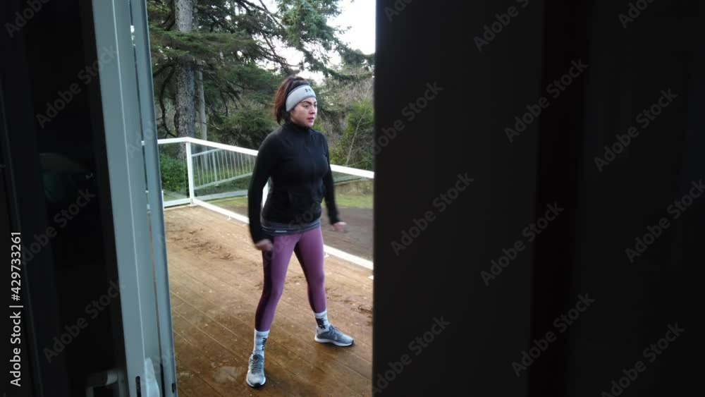 Reveal of female runner warming-up and stretching legs before run on home balcony Reveal of female runner warming-up and stretching legs before run on home balcony