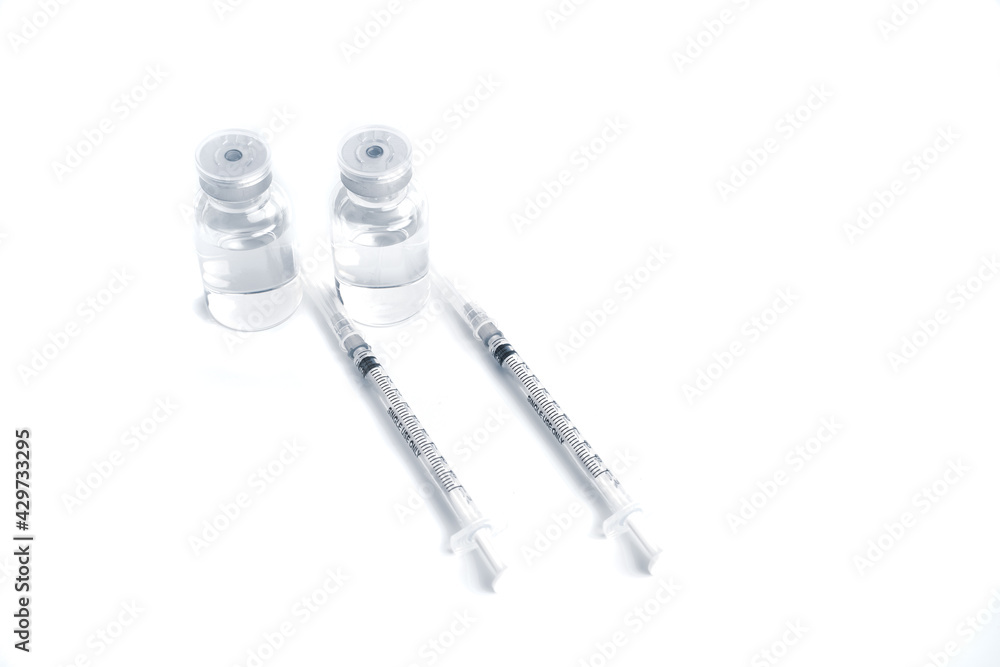 Empty bottle of vaccine with syringe for hygiene injection. Pharmaceutical equipment protective infection of pandemic covid-19 virus, flu, disease. Isolated on white background, copy space. Empty bottle of vaccine with syringe for hygiene injection. Pharmaceutical equipment protective infection of pandemic covid-19 virus, flu, disease. Isolated on white background, copy space.