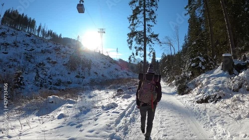 a boy walk uphill a winter paths of polish Tatra mountains