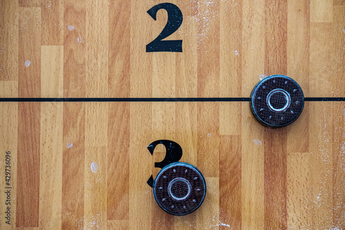 Shuffleboard pieces sit on a shuffleboard