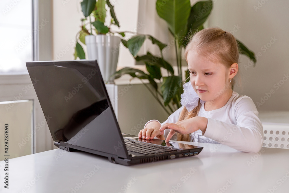 The girl learns (communicates, talks) through a computer / laptop The girl learns (communicates, talks) through a computer / laptop