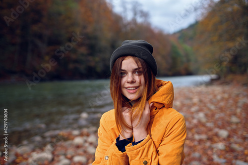 woman walks in the autumn forest in a yellow jacket mountains travel
