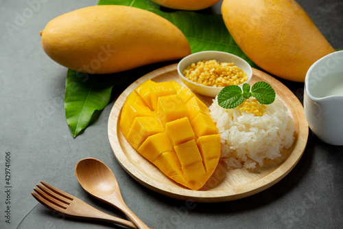 Fototapeta Naklejka Na Ścianę i Meble -  fresh ripe mango and sticky rice with coconut milk on dark background