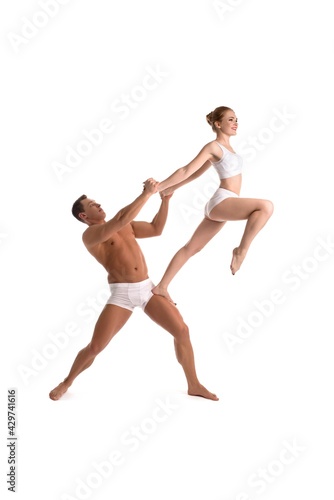 Young athletic couple doing acrobatic support exercise
