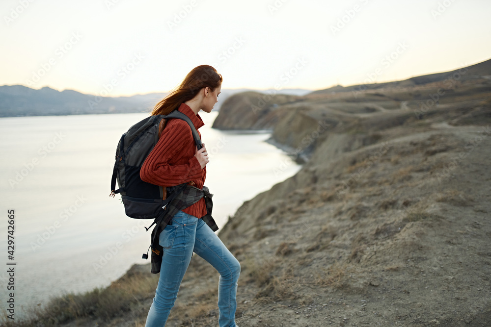 woman climbs the mountains and look at the sea in the distance landscape clouds travel tourism