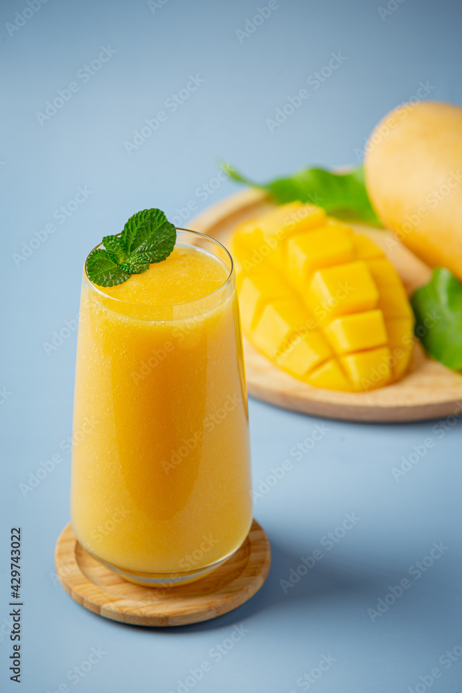 Mango juice in the glass on blue backgroud Mango juice in the glass on blue backgroud