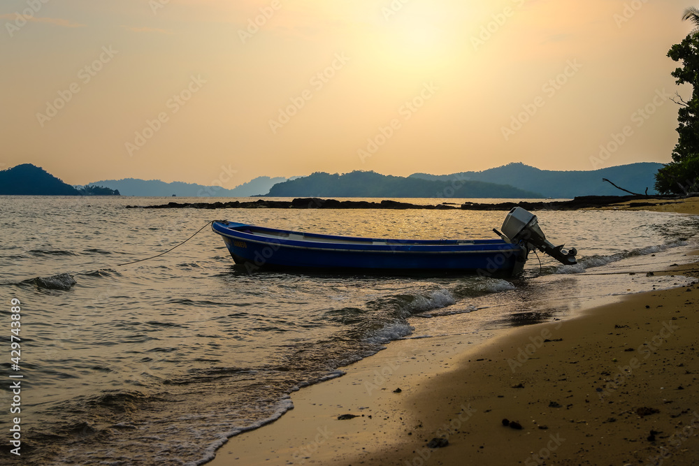 The boat is moored by the beach and at sunset. Space for text The boat is moored by the beach and at sunset. Space for text