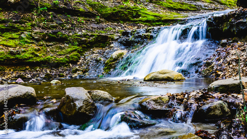 Waterfall in the forest with green mossy rock.