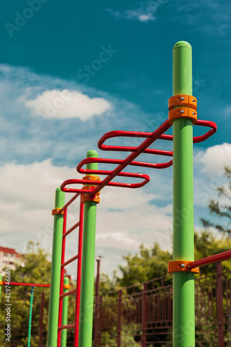 green and red horizontal bars on a playground in the summer 