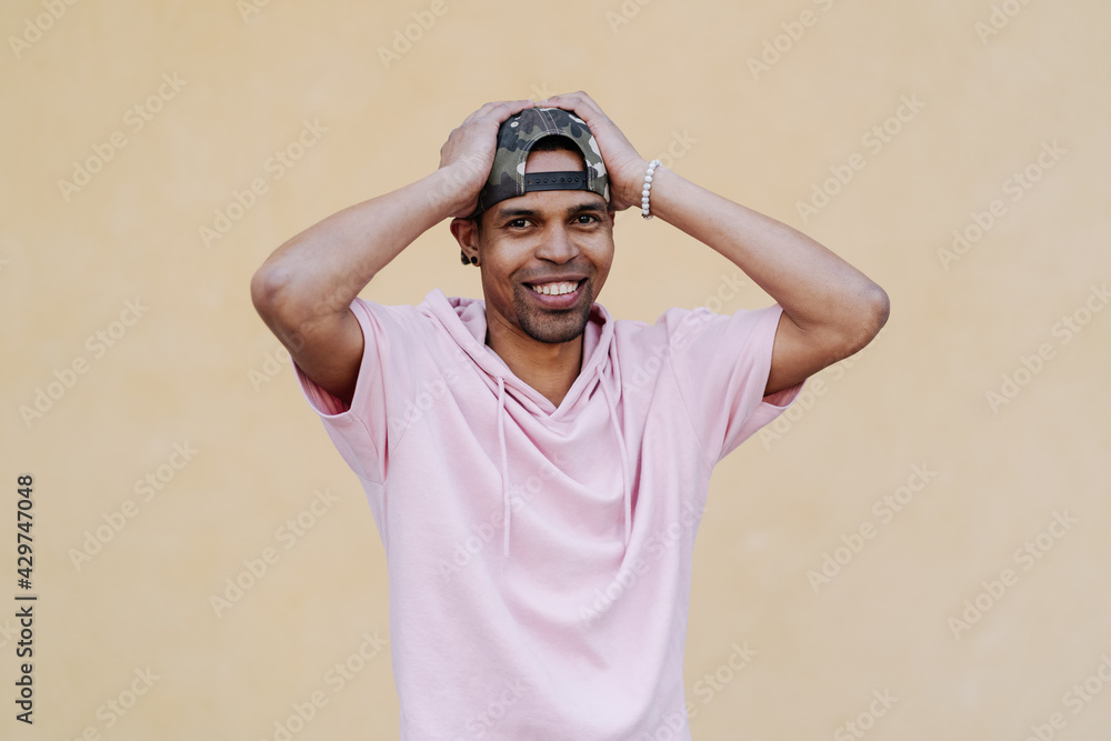 Naklejka premium What a lucky guy I am. Shot of man who can not believe in his own happiness, being excited and feeling like on heaver from joy, holding hands on hair, surprised over yellow background
