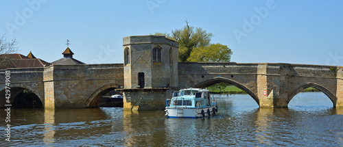 Historic bridge over the river Ouse at St Ives Cambridgeshire with river cruiser  photo