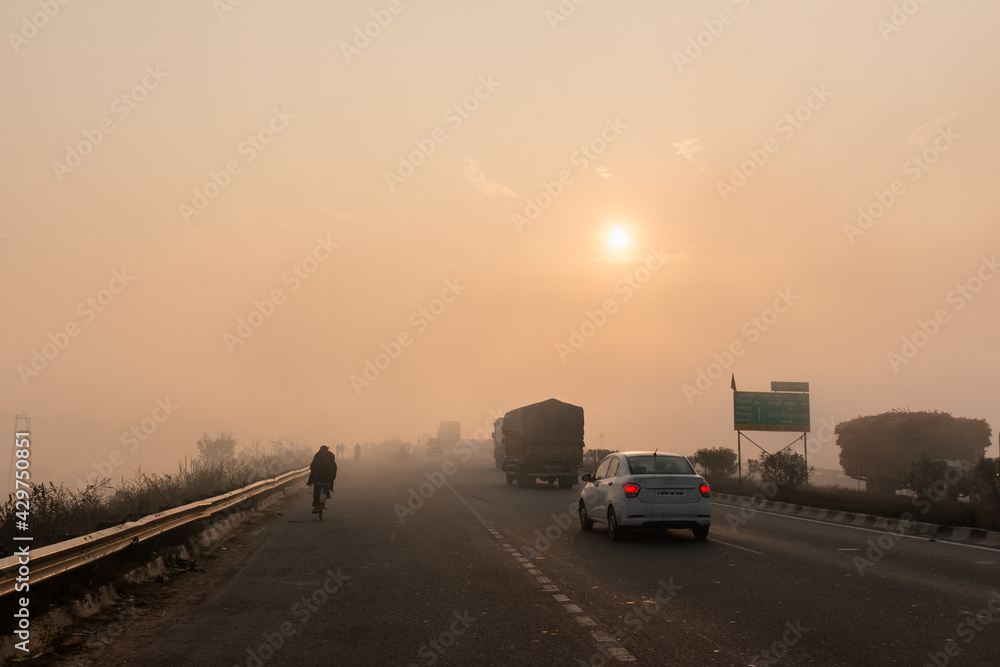 Indian Road Highways, Beautiful landscape of Indian roads during fog and sunrise in winter morning. Vehicles running on highways. Indian Road Highways, Beautiful landscape of Indian roads during fog and sunrise in winter morning. Vehicles running on highways.