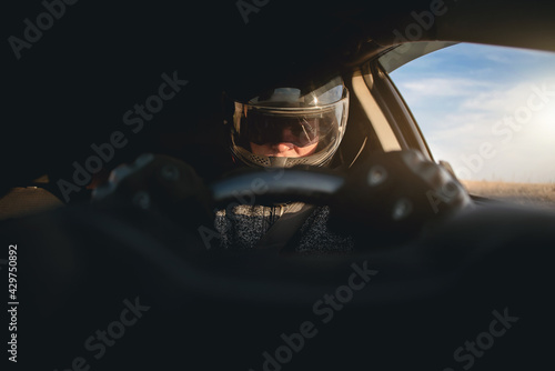 Rally racer in a helmet is driving a car concept. © Dmitriy