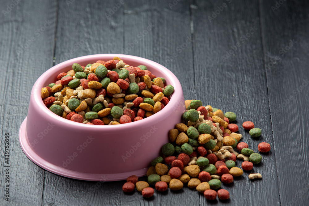 dry dog food in bowl on dark wooden backgroud dry dog food in bowl on dark wooden backgroud