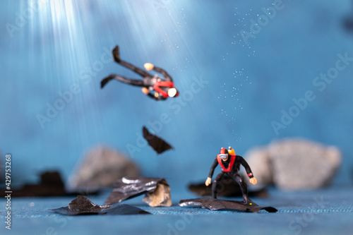 Miniature people   Scuba diver cleans up plastic rubbish pollution discarded in ocean  underwater pollution concept