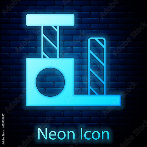 Glowing neon Cat scratching post with toy icon isolated on brick wall background. Vector