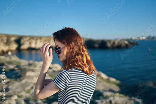 woman in mountains near blue lake summer vacation model glasses landscape
