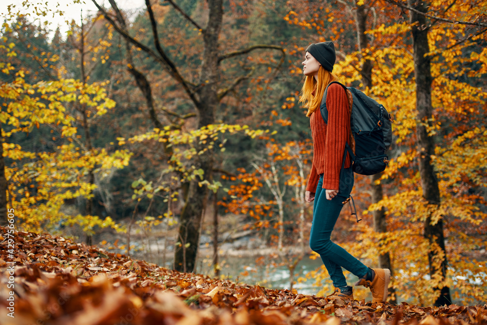 woman in autumn forest near river landscape yellow leaves tourism