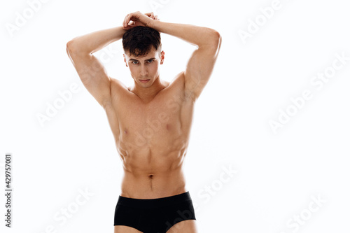 male athlete in black shorts hold hands behind head cropped view isolated background