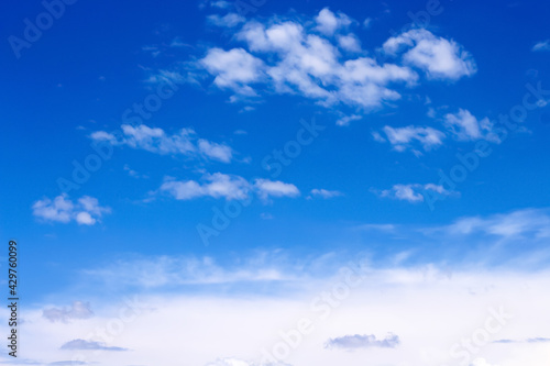 White clouds on vast bright blue sky summer close up background