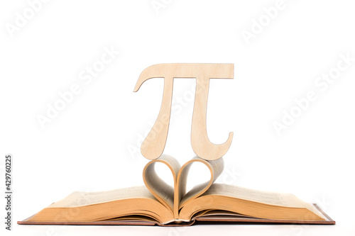 The Greek letter Pi made of wood with your own hands on the sheets of a textbook in the shape of a heart in honor of the International Pi Day on March 14