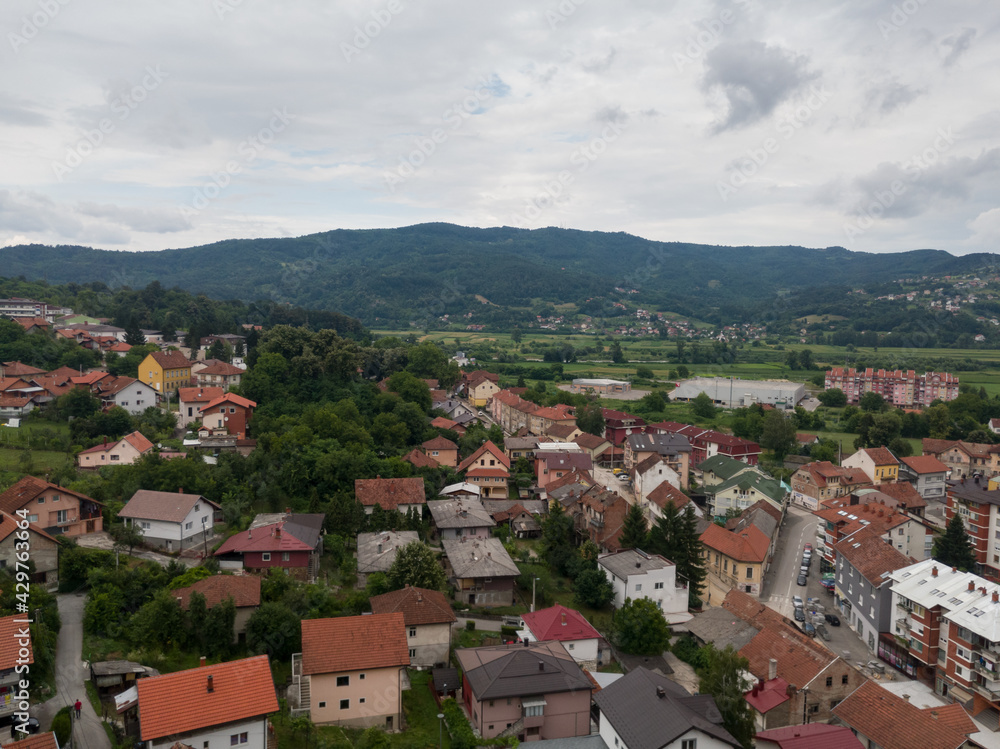 Obraz premium Aerial view of Doboj and hilly countryside from medieval fortress Gradina during overcast summer day.