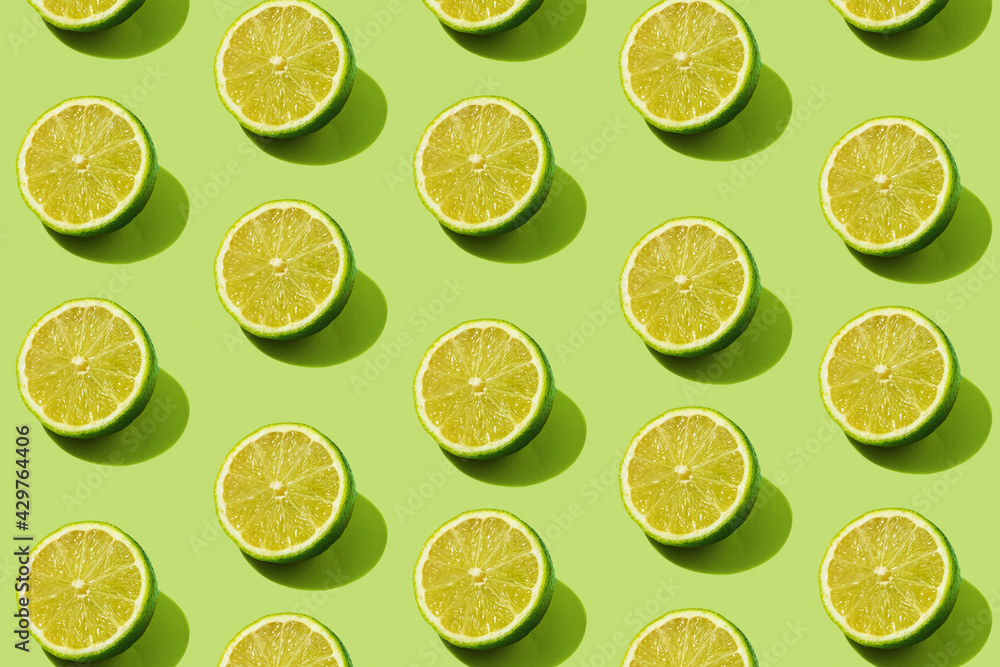 Modern pattern with lime slices on a green background illuminated by bright summer sunlight - Pop art design minimal creative concept - Flat lay composition