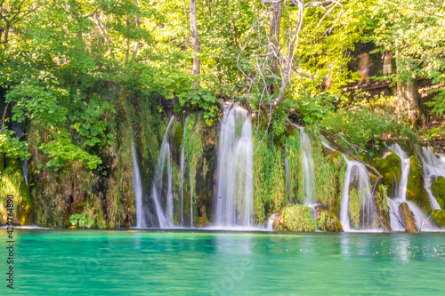 Fototapeta Naklejka Na Ścianę i Meble -  Waterfalls flowing into the crystal water of Lake Plitvice