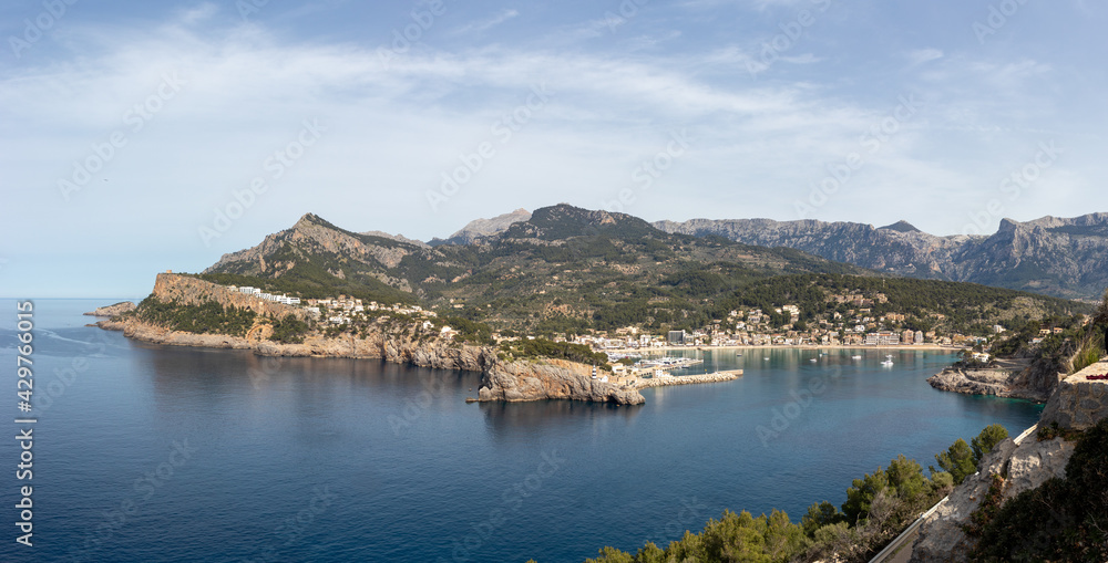 Panoramic view of port de soller with lighthouse and bay, mallorca spain.