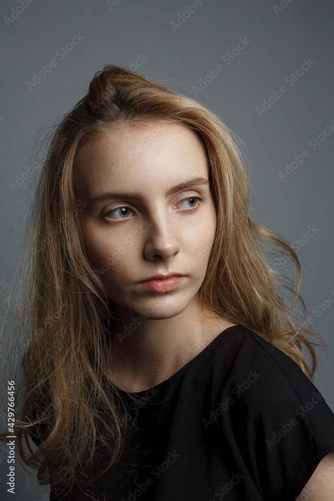 cute young pretty woman with long hair in shirt posing on grey background cute young pretty woman with long hair in shirt posing on grey background