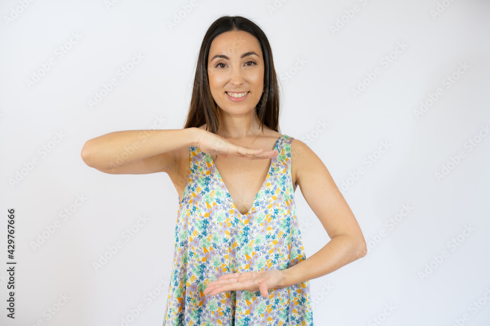 Young woman over isolated background holding something with both hands, product presentation. Young woman over isolated background holding something with both hands, product presentation.