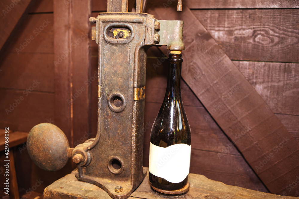 Retro style wine bottle sealing machine. An ancient tool for demonstrating historical processes. Close-up Retro style wine bottle sealing machine. An ancient tool for demonstrating historical processes. Close-up