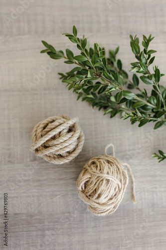 material for making home decor in the eco style. a tangle of jute cord and rope on a wooden table. a branch of living greenery.the concept of home decor and comfort in the eco style.