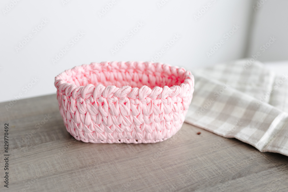 rectangular basket made of pink knitwear, on the table. white background rectangular basket made of pink knitwear, on the table. white background