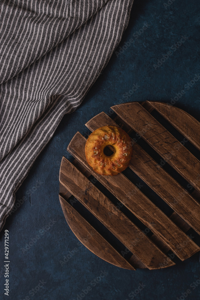 A pumpkin muffin on a wooden lattice on a dark blue background A pumpkin muffin on a wooden lattice on a dark blue background