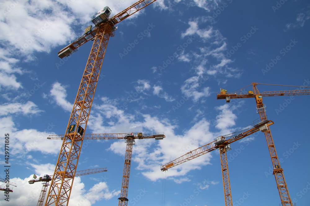 some big cranes ahead a blue sky with clouds some big cranes ahead a blue sky with clouds