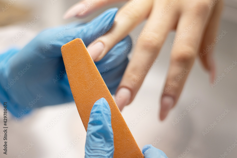 Φωτογραφία process of filing nails manicure in the salon, removing gel polish or acrylic fr