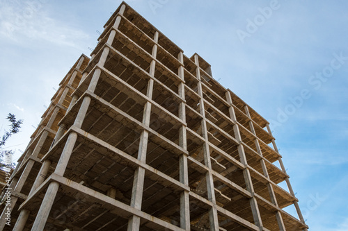 Structure of an abandoned building under construction, in a sunset with blue sky and a little cloudy.