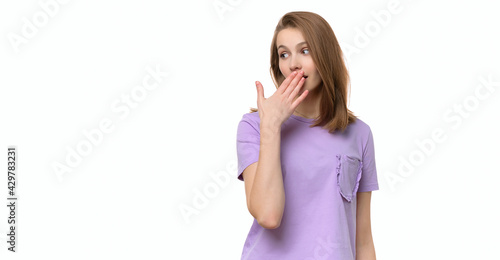 Fototapeta Young woman covering mouth with hand, looking serious, promises to keep secret