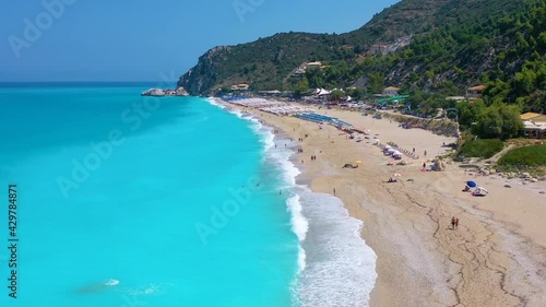 The popular Kathisma Beach on the Greek island of Lefkada with blue sea and rows of umbrellas, Greece photo